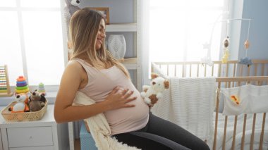 Hamile bir kadın yatak odasında oturmuş oyuncak tutuyordu. Yanında beşiği vardı. Bu da annelik beklentisi ve sıcak bir iç mekan olduğunu gösteriyordu.