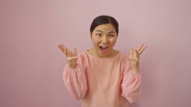 Pembe bluzlu kadın pembe bir duvara karşı heyecanını ifade ediyor. Güzelliğini ve enerjisini neşe dolu bir ortamda sergiliyor..