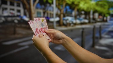 Kentsel caddede el ele tutuşan Meksika pezoları, şehirde erkek varlığıyla birlikte yatırım ve mali işlemleri resmediyor..