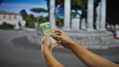 Güney Afrika rand banknotlarını bir sokakta elinde tutan adam, açık hava ortamında para yönetimini sergiliyor..