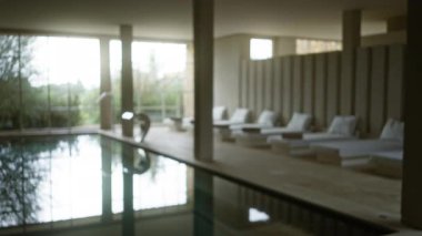 Dinlenme ve gençleşme için sakin ve cezbedici bir ortam yaratan şezlonglar ve yumuşak ışıklandırma ile huzurlu bir spa havuzu manzarası..