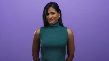Latin kökenli genç bir kadın, elleri ile dışlanmış mor bir arkaplan karşısında reddediliyor, açık bir stüdyo ortamında duygularını ve vücut dilini sergiliyor..