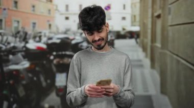 Kentsel sokak ortamında gülümseyen ve arka planda park edilmiş motosikletleri olan Norveç kronu banknotları tutan adam..