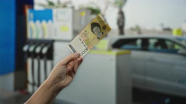 Güney Kore 'yi elinde tutan adam benzin istasyonunda açık havada para alışverişini ön plana çıkaran otomobil ve yakıt pompalarıyla banknot kazandı..