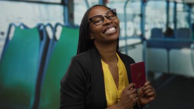 Otobüste elinde Tayland pasaportuyla gülümseyen, gözlüklü ve sarı gömlekli bir kadın, toplu taşıma aracında seyahat ve kimlik teşhir ediyor..