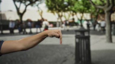 Bulanık şehir ağaçları ve arka plandaki insanlarla çevrili işlek bir caddede erkek el çabukluğu onay ve olumlu bir jestin göstergesidir..