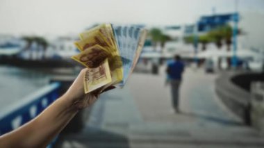 Bir şehir caddesinde arka planda yürüyen bir adam ve kadınla el ele tutuşan Macar banknotları kentsel bir ortamda mali değişim öneriyor..