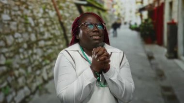 Steteskoplu bir kadın soğuk algınlığından titreyen, gözlüklü ve beyaz ceketli, şehir manzarası ile çevrili, soğuk bir hava veriyor..