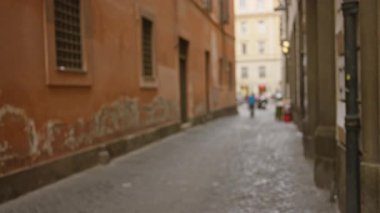 Roma 'daki bulanık sokak manzarası, dağılmış figürlerle tarihi mimariyi gözler önüne sermek, İtalyan eski kasaba cazibesinin ve atmosferik kent ortamının özünü yakalamak..