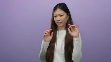 Mor bir arkaplan önünde suratını buruşturan Asyalı kadın iğreniyor..