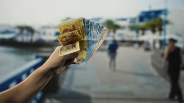 Meşgul bir şehir caddesinde elinde Macar banknotları tutan adam ekonomik faaliyetleri yakalıyor ve yurtdışına seyahat ediyor..