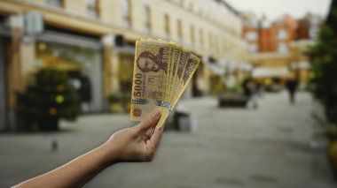 Macar banknotlarını elinde tutan adam şehir caddesinde, Hungary 'deki açık hava kentsel faaliyetlerini yakalıyor..