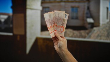 Kentsel çevre düzenlemelerinde Singapur banknotları tutan adam sergiler mali işlemler ve uluslararası iş atmosferi.