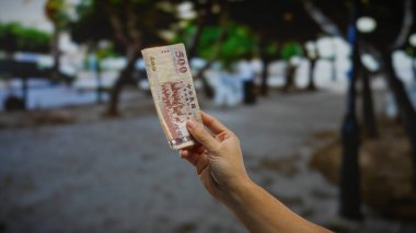 Şehir ortamında el ele tutuşan Tayvan banknotları, hareketli bir kasaba atmosferinde yatırım, finans ve ticari işlemleri vurguluyor..