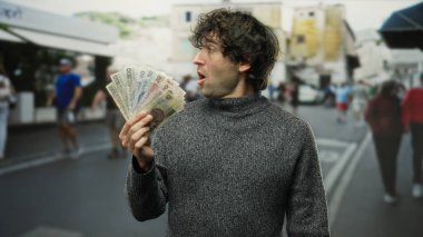 Czech Koruna banknotlarını elinde tutan adam şehir dışındaki şehir merkezinde beklenmedik bir servet servetini gösteriyor..