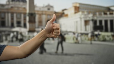Aziz Peter Meydanı, Vatikan 'ın önünde uzanan ve ikonik dış mekanda olumlu jest gösteren bir adam baş parmak kaldırıyor..