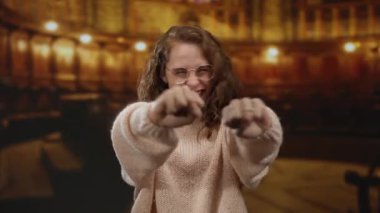 Sıcak bir kilise ortamında sevinç ifade eden genç bir kadın, coşkulu jestleri canlı ve neşeli bir ruh halini vurguluyor..