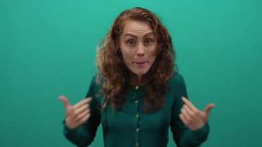 Canlı yeşil bir arka plan karşısında heyecanlı jestler yapan kadın kıvırcık saçlarını ve hareketli bir portrede canlandırılmış yüz ifadelerini vurguluyor..