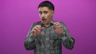 İspanyol desenli gömlekli genç adam, tecrit edilmiş pembe bir duvardan korkmuşa benziyor..