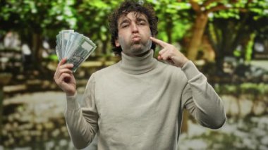 Parkta elinde bangladeş banknotları olan İspanyol bir adam, zenginlik ve mutluluğu yemyeşil arka planda gösteriyordu..