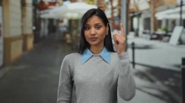 Sokakta kafasını gösteren genç bir kadın. Düşünceli bir ifadeyle. Şehirli bir sonbahar manzarası sergiliyor..