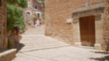 Mallorca, İspanya 'daki bir açık hava sahnesinin bulanık arkaplanı, kırsal taş basamakları ve binaları gözler önüne seriyor.