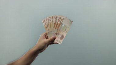 Güney Kore 'yi elinde tutan adam, mali zenginlik ve para biriminin odak noktasını gösteren sade beyaz arka plana karşı para kazandı..