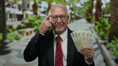 Üst düzey bir adam elinde Czech Koruna banknotları, gözlüklü ve takım elbiseli, parmaklarıyla kafaya dokunuyor, sokak düzeninde akıllı finansal tavsiyeler veriyor..