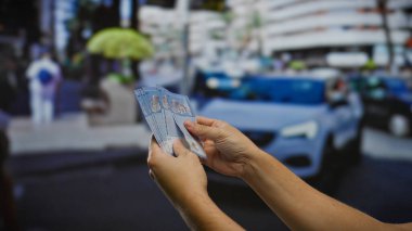 Şehir caddesinde taksinin önünde Malezya halkaları tutan adam, kentsel iş ve döviz kurlarını yakalıyor..