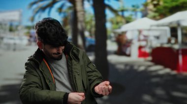 Sokakta hayali bir halatı çeken, ceketli, şehir planlı, neşeli bir şehir anını yakalayan İspanyol genç adam..