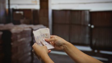 Kapalı alanlarda tek kişilik dolar tutan adam, şehir ortamında para değişimi gösteriyor. Finans, yatırım ve küresel iş fırsatları öneriyor..