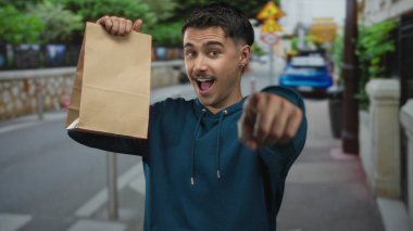 Şehrin sokaklarında elinde kağıt torbalarla gezen genç bir İspanyol, neşeli bir şekilde dışarıya bakıyor. Heyecanlı ve canlı bir ifade sergiliyor..