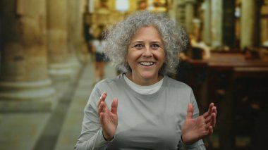 Kilisede gri saçlarıyla gülümseyen bir kadın olgun bilgeliği ve dinginliği temsil eden süslü bir mimarinin ortasında neşeli bir ifade sergiliyor..