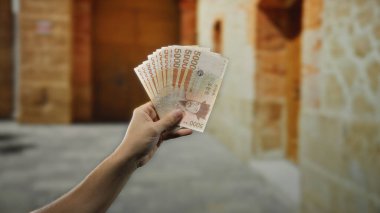 Güney Kore 'yi elinde tutan adam şehir dışındaki bir sokakta para kazandı. Canlı bir şehir ortamında para sergiliyordu..