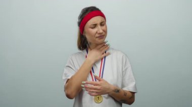 Kırmızı bantlı ve madalyalı beyaz gömlekli bir kadın boğazını beyaz bir arka plana dayayıp rahatsızlık ya da gerginlik hissi veriyor..