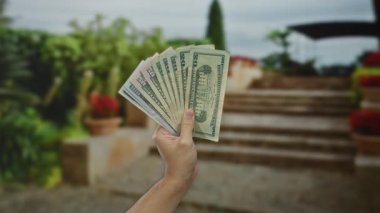 Amerikan dolarlarını açık havada tutmak, şehir ortamında para sergilemek, finansal temaları ve kentsel yaşam tarzını ön plana çıkarmak..