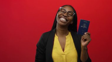 Avustralya pasaportu taşıyan kadın canlı kırmızı duvara gülümsüyor, seyahat için mutluluk ve heyecan saçıyor, neşe dolu maceraya hazır olduğunu gösteriyor..