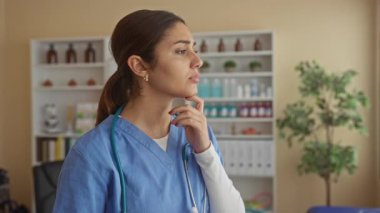 Bir hastane odasında önlük ve steteskop takmış tıbbi malzemelerle kafa yoran İspanyol bir hemşire..