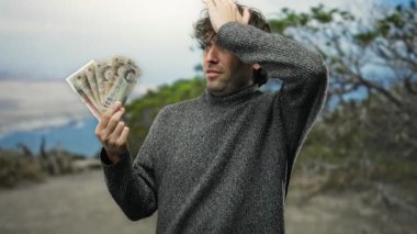 İspanyol adam parkta İngiliz paundu tutuyor. Ağaçlarla duygularını ifade ediyor..