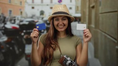 Bir sokakta boynunda bir kamerayla gülümseyen genç İspanyol kadın bir seyahat konseptini gösteriyor..