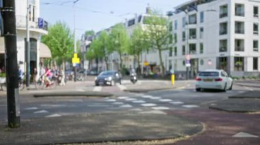 Kalabalık bir Avrupa şehir caddesinin bulanık manzarası. Arabalar ve motorsikletlerle. İnsanlar kentsel açık hava ortamında hareket ediyor..