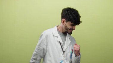 Sarı arka planda izole edilmiş, hevesli ve profesyonel bir tavır sergileyen labaratuvar önlüklü genç İspanyol.