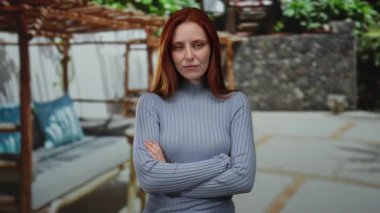 Şehir dışında, şehir geçmişine karşı ciddi bir ifadeyle duran kadın.