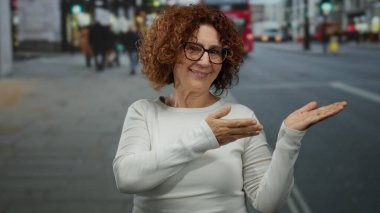 Yoğun şehir sokağında arka planı bulanık şehir ortamını, hareketini, gün ışığını gözler önüne seren canlı şehir yaşamını sunan bir kadın..