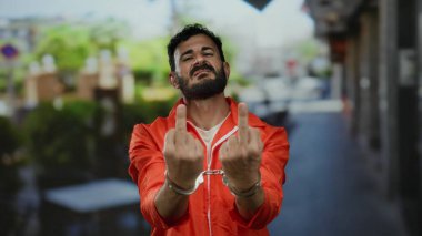 Turuncu hapishane tulumlu ve kelepçeli İspanyol adam şehir caddesinde meydan okuyarak açık havada meydan okuyor..