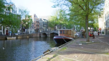 Tuğladan evler ve ağaçlarla kaplı Amsterdam Kanalı 'nın bulanık görüntüsü Hollanda' da deniz manzarası boyunca rüya gibi bir bokeh etkisi yaratıyor..