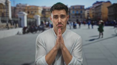 Genç İspanyol adam, Vatikan 'ın St. Peter Meydanı' nda insanlarla ve arka planda mimariyle birlikte açık hava ortamını vurgulayarak yalvarıyor..