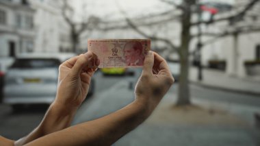 Şehir sokaklarında elinde Türk lirası banknotları tutan bulanık şehir geçmişi olan bir adam, günlük hayatta canlı bir açık hava para birimi görüntüsü yakalıyor..