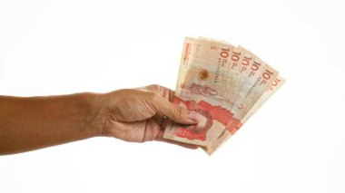 El ele tutuşan Kolombiya pesoları izole edilmiş beyaz arka planda, açık ve minimalist bir ortamda canlı para birimi sergiliyor..