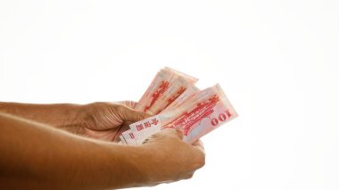 Tayvan dolarlarını izole edilmiş beyaz arka planda tutan eller mali işlemleri veya ödemeleri akla getiriyor.